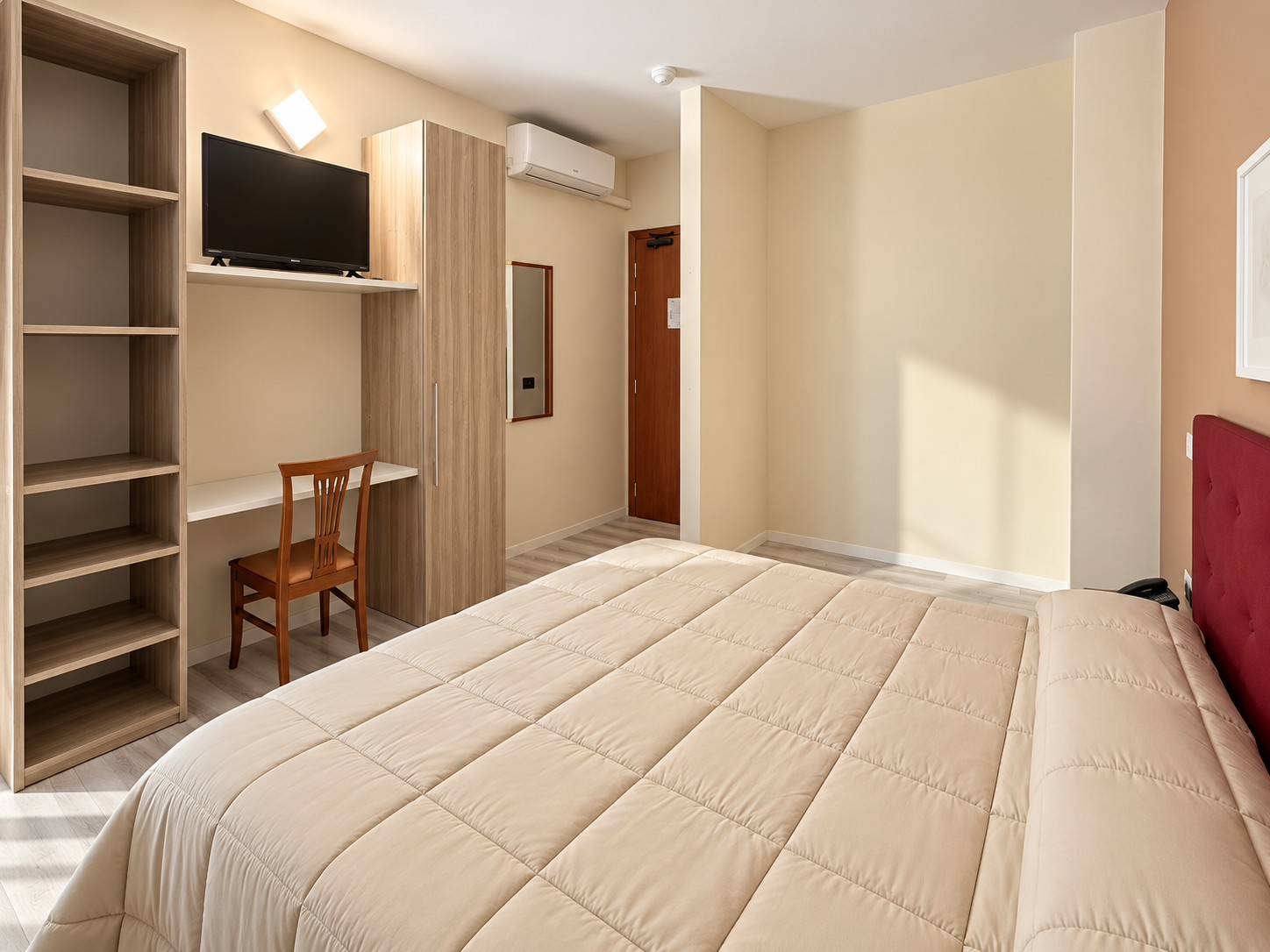 Camera da letto d’hotel luminosa e accogliente copy