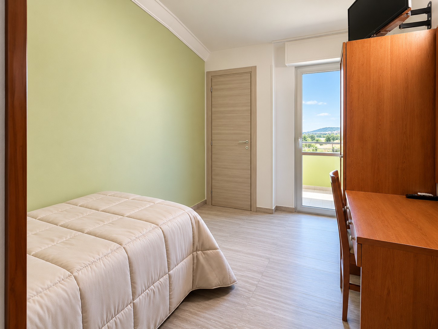 Camera d’albergo luminosa con vista sul balcone
